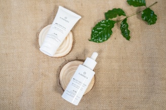 Hands applying natural skincare products on a wooden table