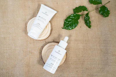 Beauty professional preparing natural skincare products on a wooden table.