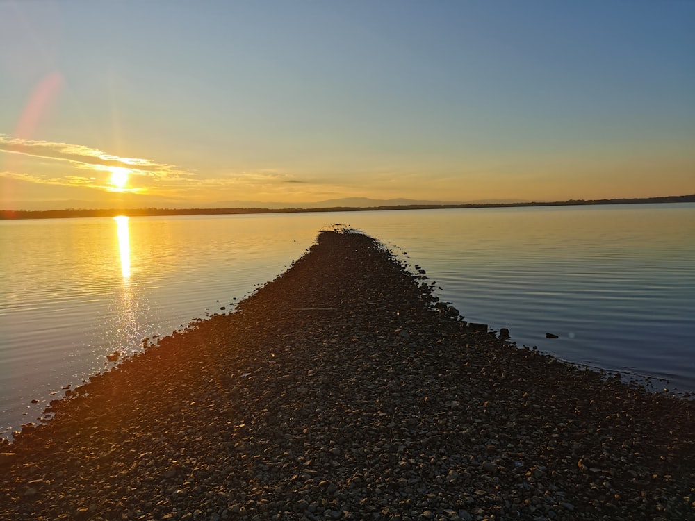 the sun is setting over a body of water