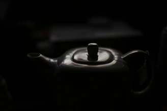 Close-up of a hand-thrown ceramic teapot with bright glaze and natural texture.