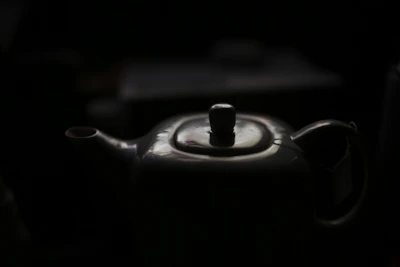 Close-up of a hand-thrown ceramic teapot with bright glaze and natural texture.