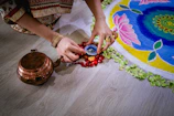 Handmade brass urli placed artistically at an entrance adorned with rangoli.