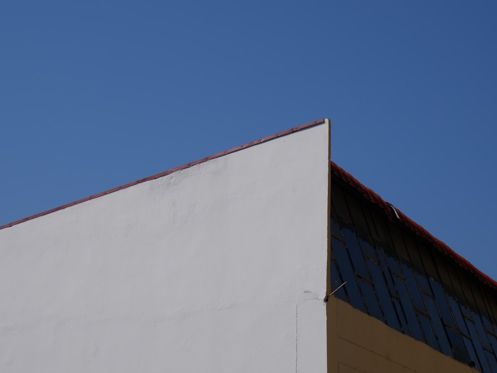 a white building with a red roof against a blue sky