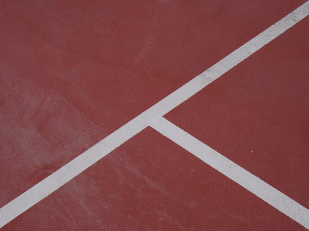 a red tennis court with white lines on it