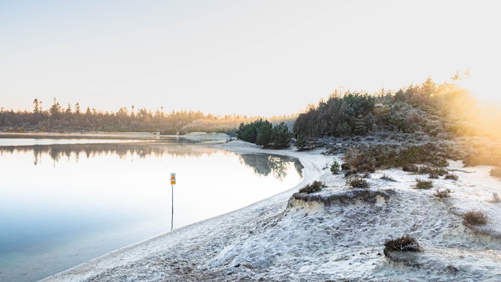 a body of water surrounded by snow covered ground