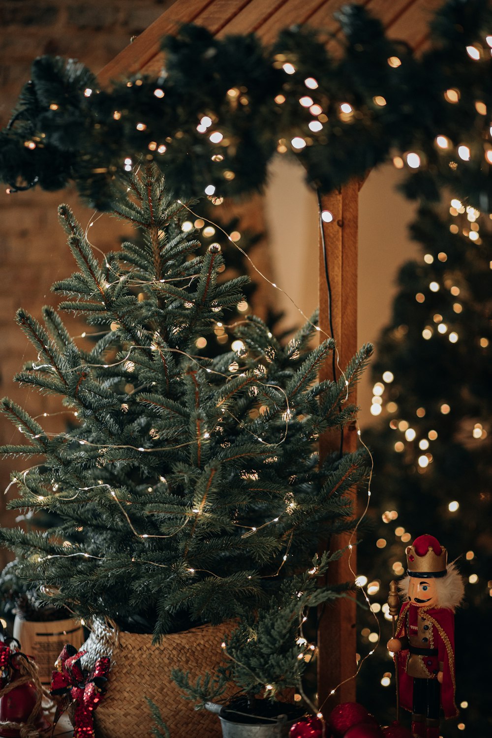 a christmas tree in a basket next to a christmas wreath