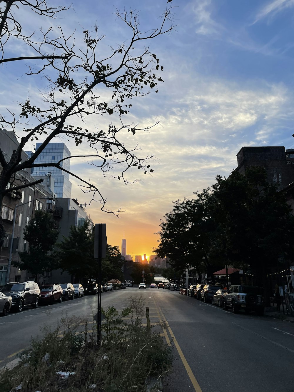 the sun is setting over a city street