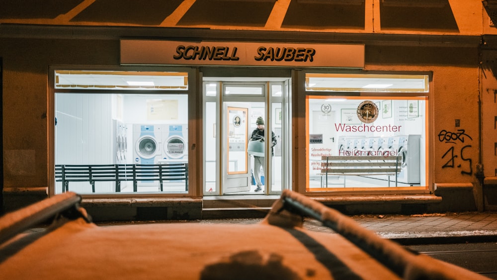 a store front at night with snow on the ground