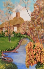 A cozy cottage topped with a warm brown shingle roof surrounded by autumn leaves.