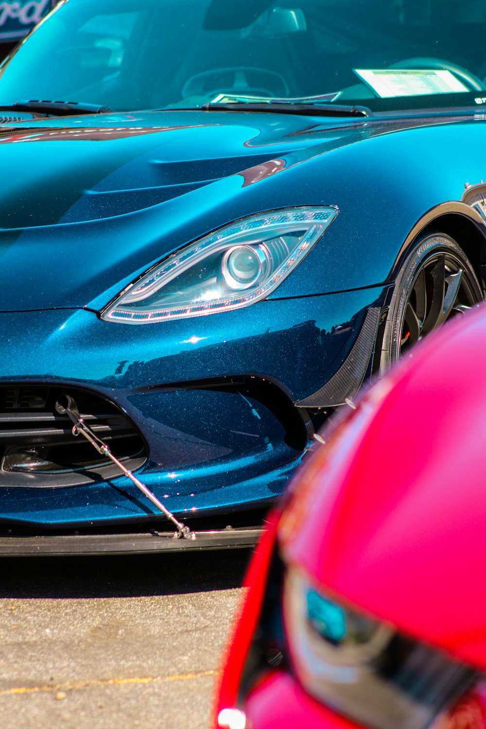 a blue sports car parked next to a red sports car