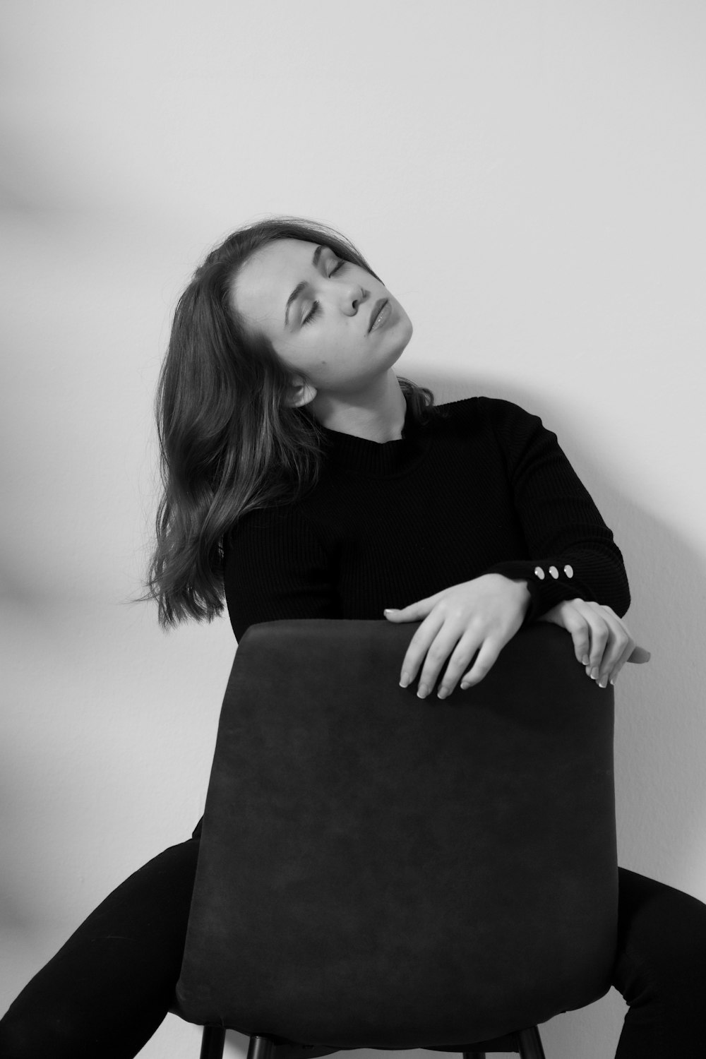 a black and white photo of a woman sitting in a chair