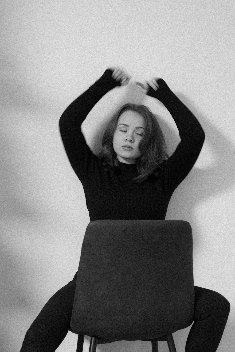 Ein Schwarz-Weiß-Foto einer Frau, die auf einem Stuhl sitzt