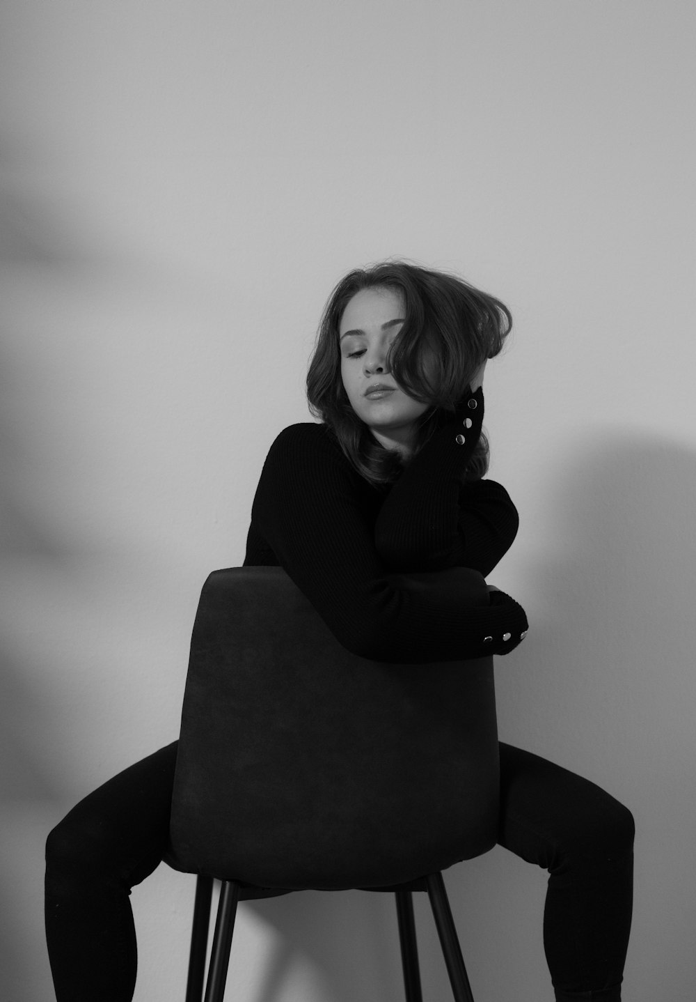 a black and white photo of a woman sitting on a chair