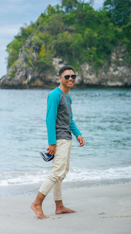 Happy person walking on the beach wearing bright rubber flip-flops.