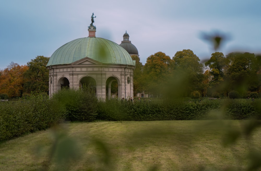 a building with a green roof surrounded by trees