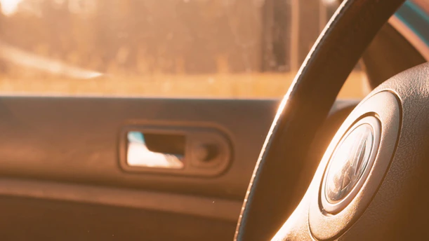 Close-up of a sparkling clean car interior with sunlight streaming through the windows.