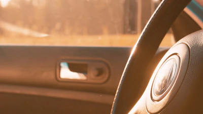 Interior shot showing a spotless, freshly detailed car cabin with warm sunlight highlighting the clean surfaces.