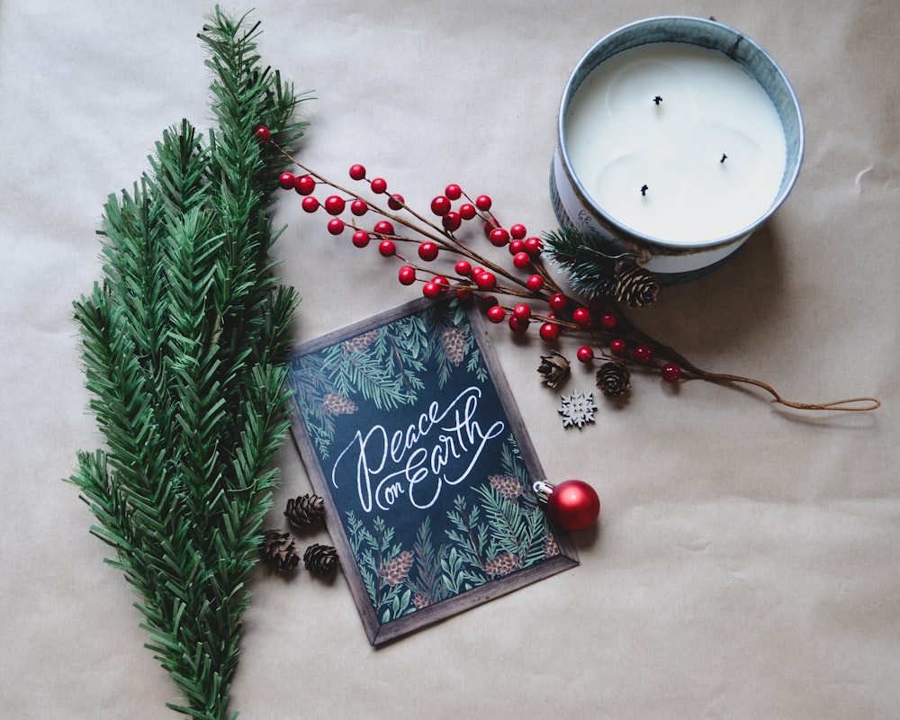 uma vela e um cartão de Natal em uma mesa