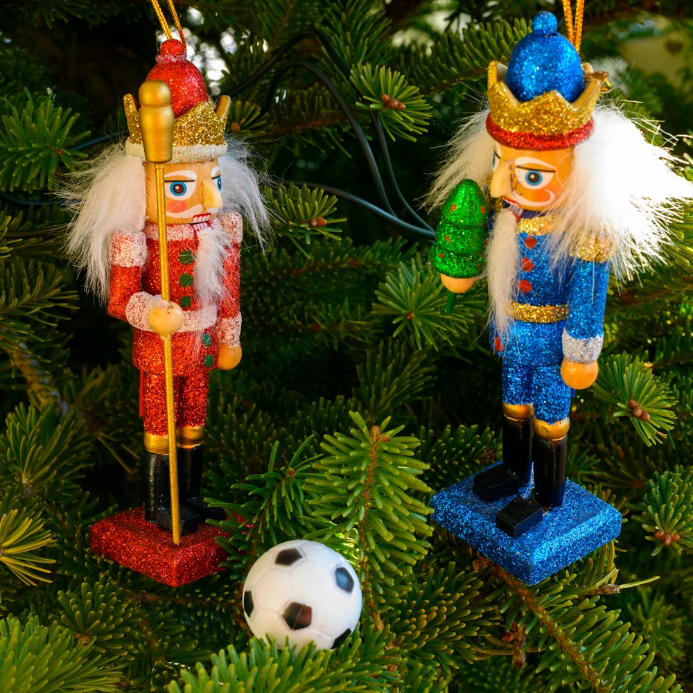 a couple of nutcrackers sitting on top of a christmas tree