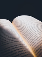 An open book with glowing pages in dim light.
