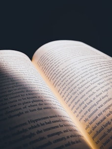 An open book with glowing pages illuminating a dark room, symbolizing knowledge and revelation.