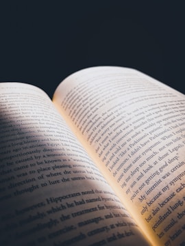 An open book with glowing pages in dim light.