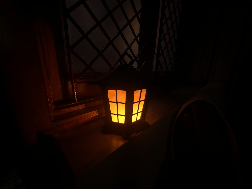 a lit lantern sitting on top of a table
