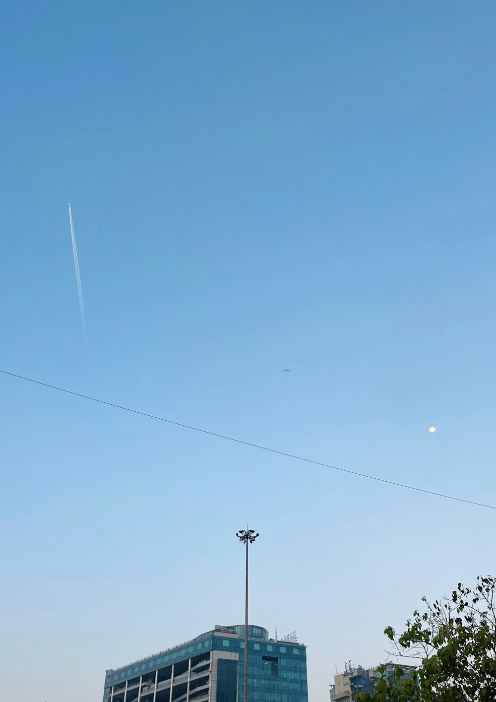 a plane flying in the sky over a building