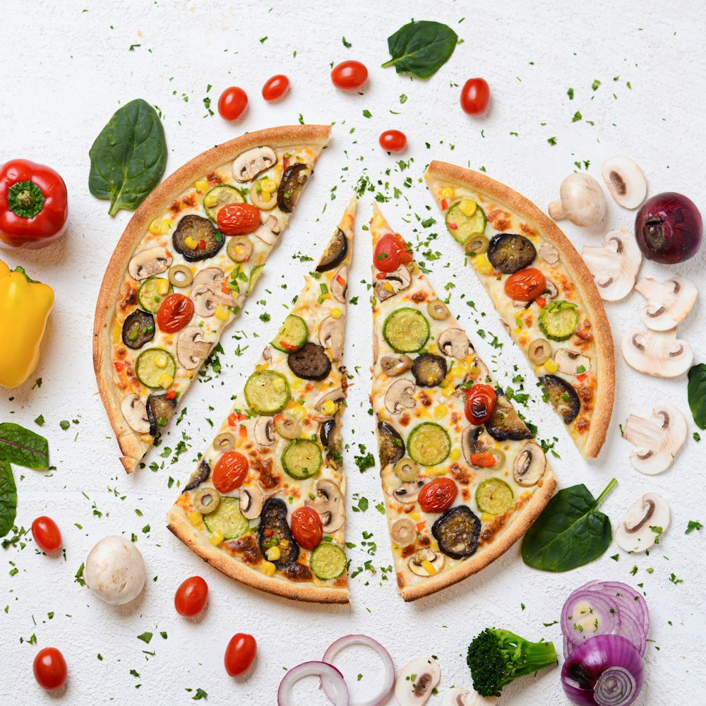 a pizza cut into slices with vegetables and mushrooms