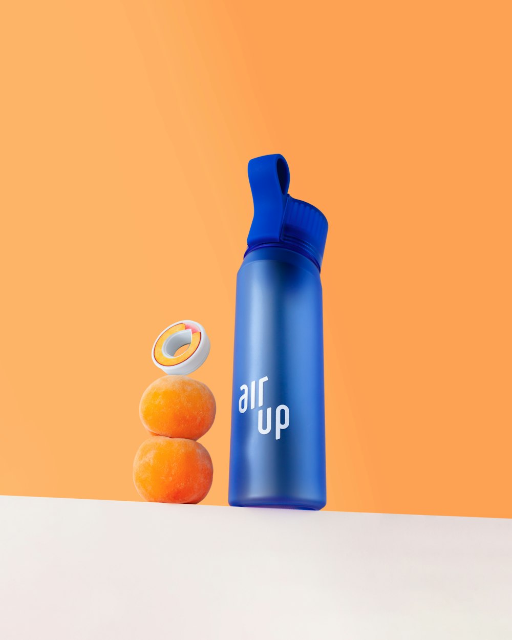 a blue water bottle next to three oranges