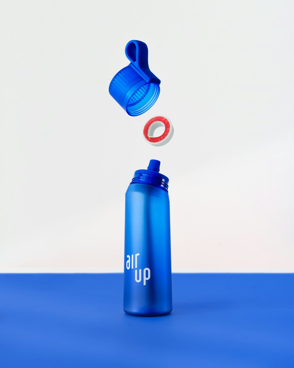 a blue water bottle with a red ring coming out of it