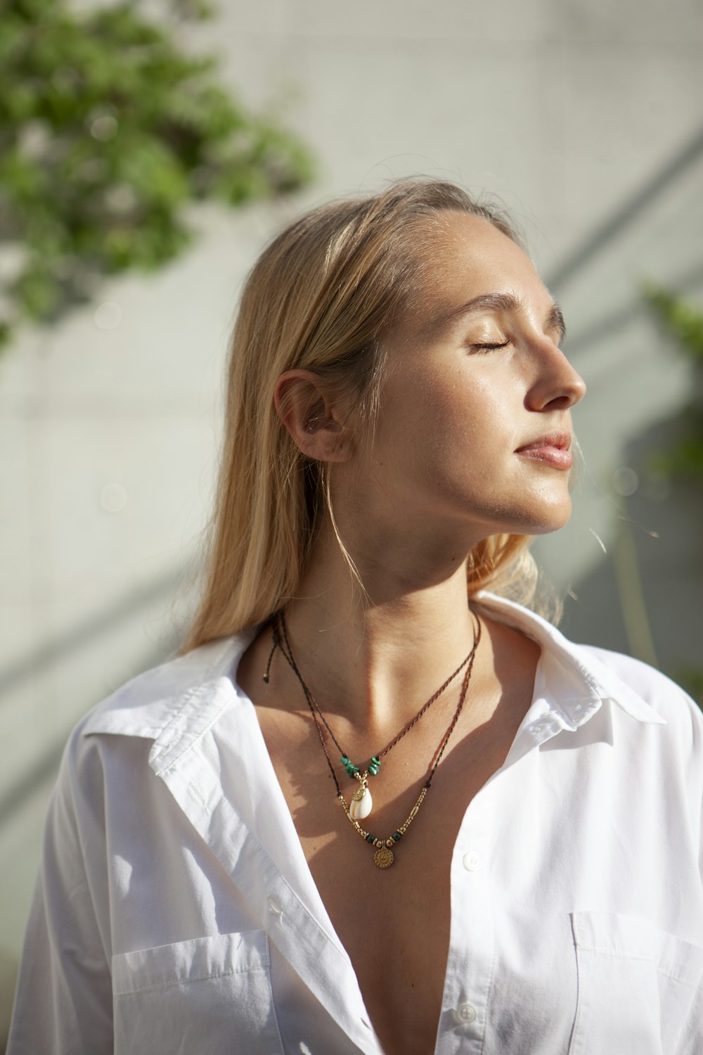 a woman wearing a white shirt and a necklace