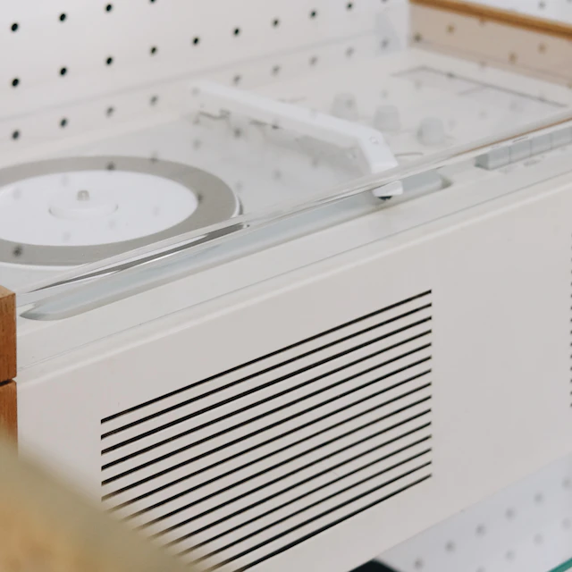 White clock sitting on a shelf in an industrial design museum display in Dresden