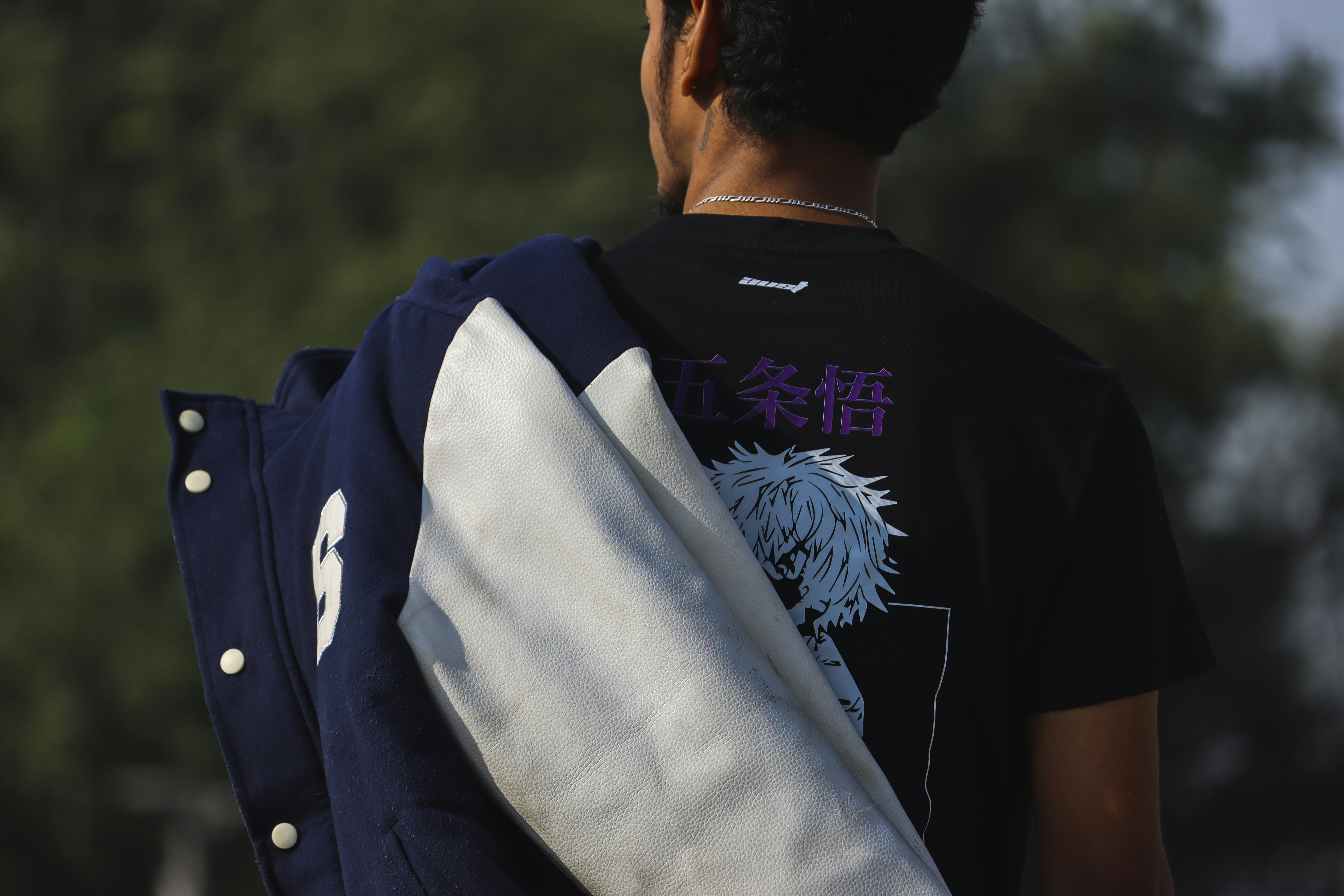 a man wearing a black shirt carrying a blue and white backpack