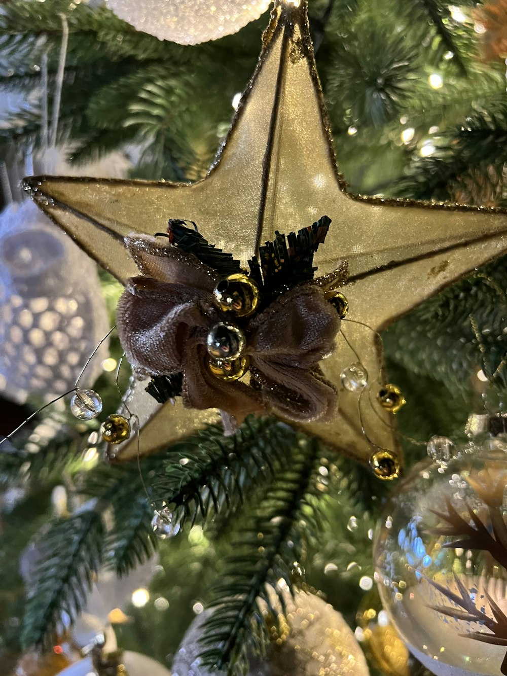 a star ornament hanging from a christmas tree