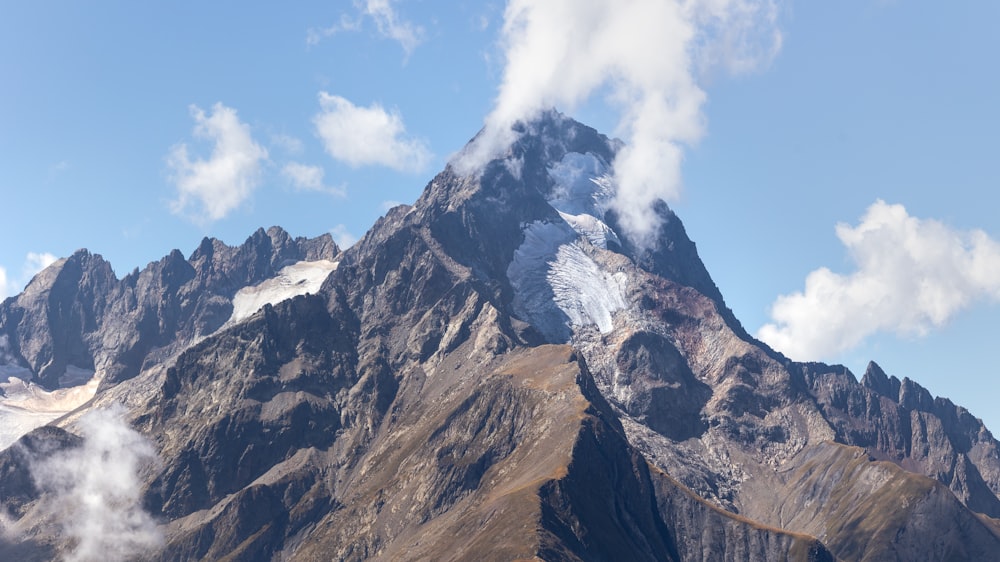 a very tall mountain covered in snow under a blue sky