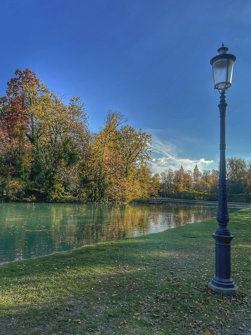 a lamp post next to a body of water