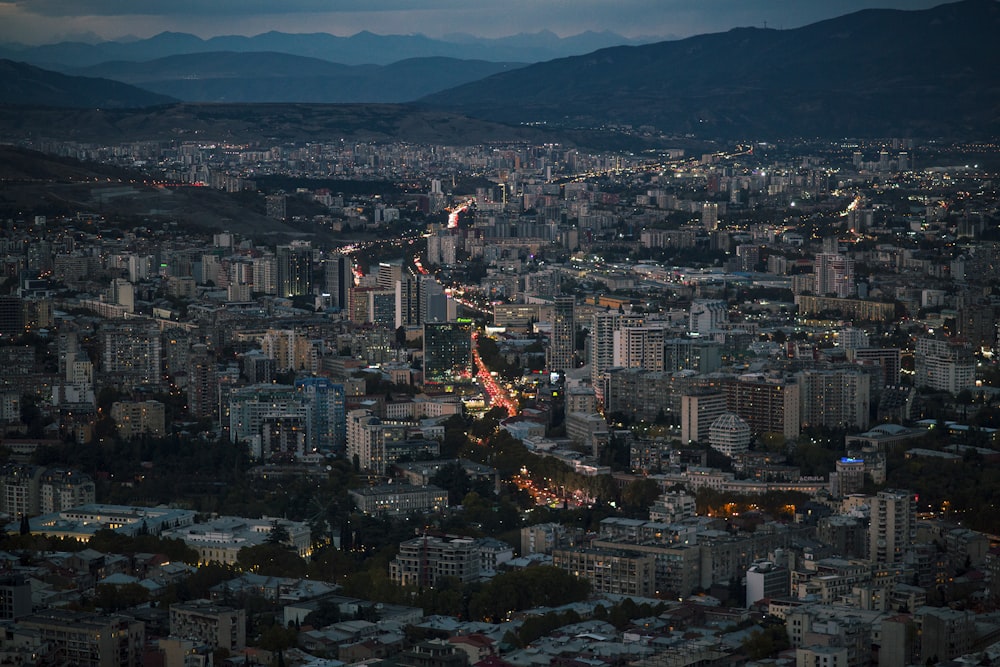 a view of a city at night with mountains in the background