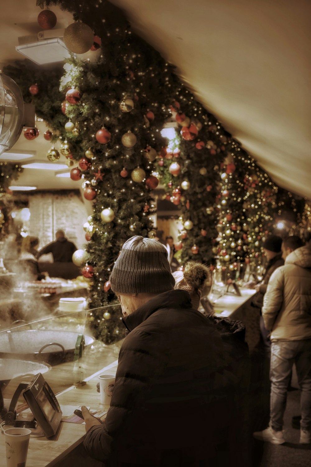 a man sitting at a table in front of a christmas tree