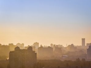 A city skyline at dawn with soft blue and white hues