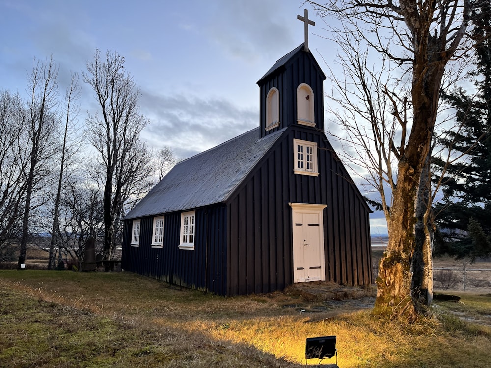 uma igreja negra com uma cruz no topo dela