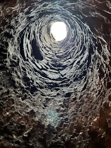 Close-up of a borewell camera being lowered into a deep well shaft.