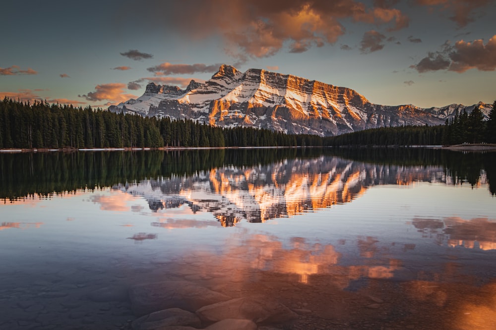 a mountain is reflected in the still water of a lake