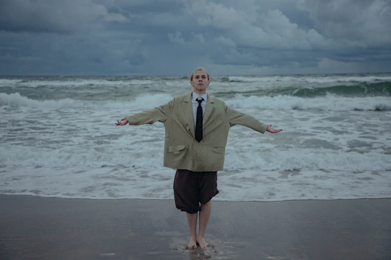 Man in a suit on a beach, combining elegance with relaxation