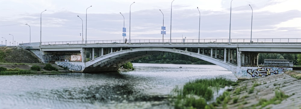 a bridge over a river with graffiti on it