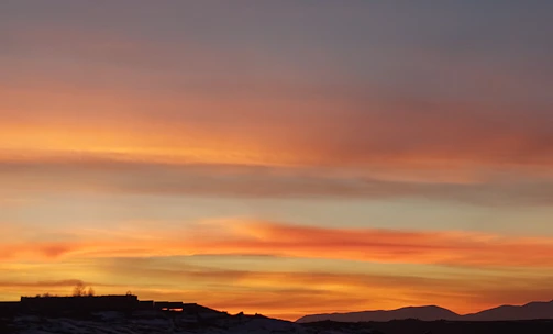 Sunset over Monterrey's Cerro de la Silla with vibrant orange and pink hues.