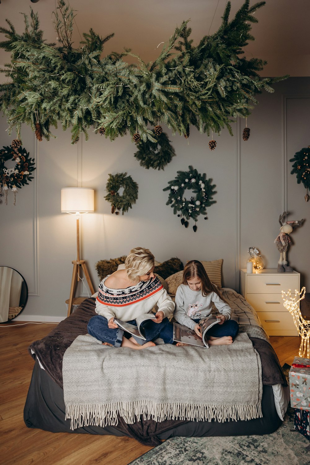 a woman and a child sitting on a bed