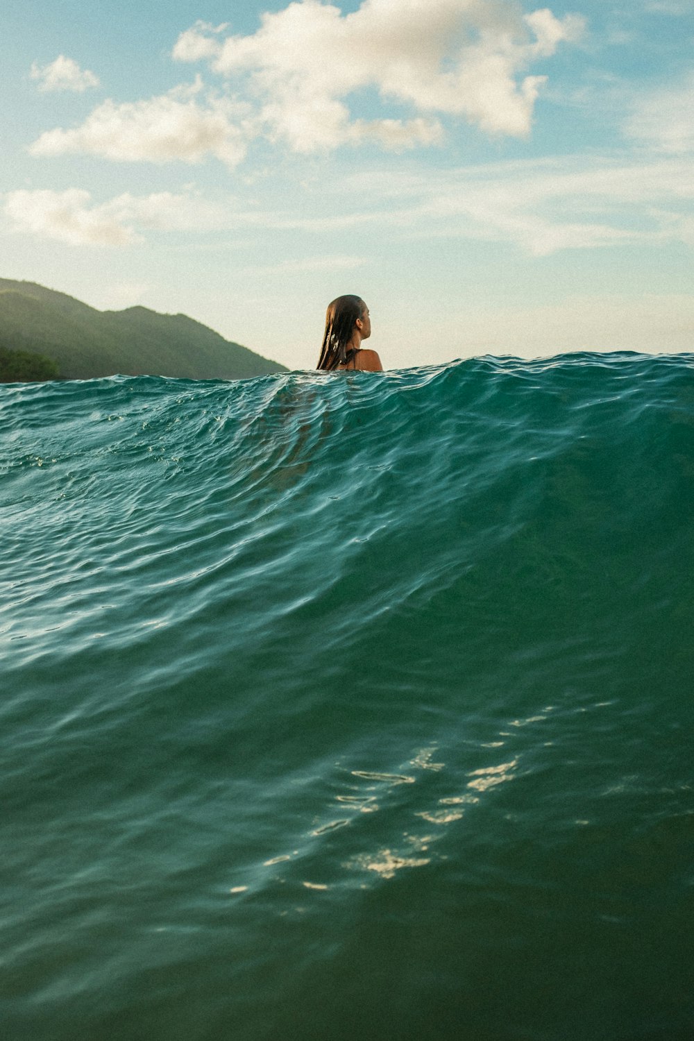 a woman swimming in the ocean on a surfboard