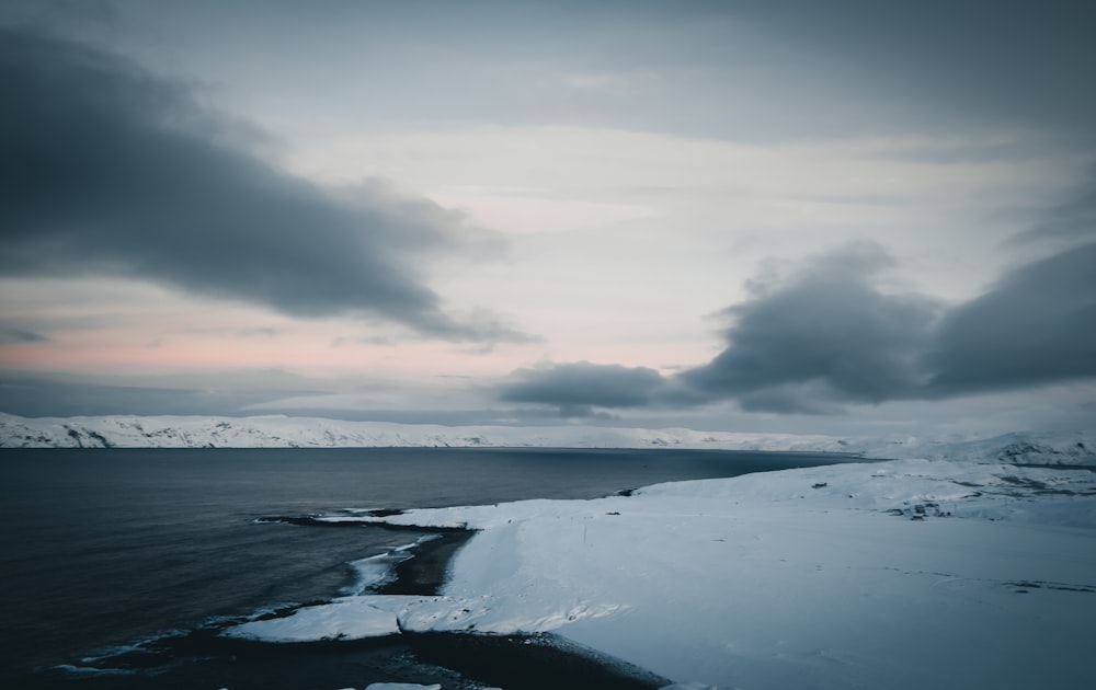 a large body of water surrounded by snow covered mountains