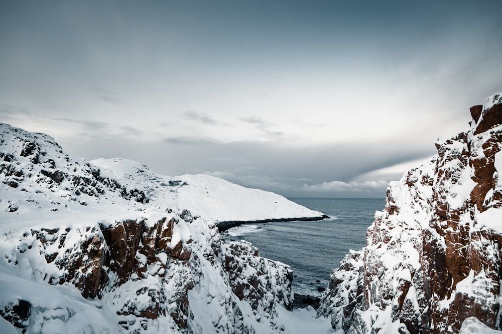 a snow covered mountain overlooks a body of water